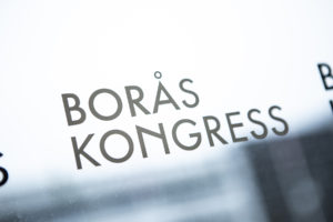 På bilden syns loggan för Borås Kongress. Den visar hur medarbetarnas prio är att deras gäster, vi vill även att gästerna ska kunna läsa mer om oss